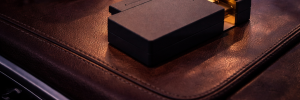 Matte silver KNNOX lighter with golden accent resting on a leather bag next to sunglasses