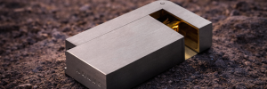 KNNOX brass lighter assembly resting on rough asphalt lit by car headlights