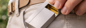 Person slipping a matte silver KNNOX lighter into a pocket