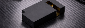 Matte black KNNOX lighter with golden accent on a carbon fiber surface