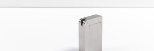 A closed silver-toned KNNOX object stands alone on a white studio surface with broad negative space.